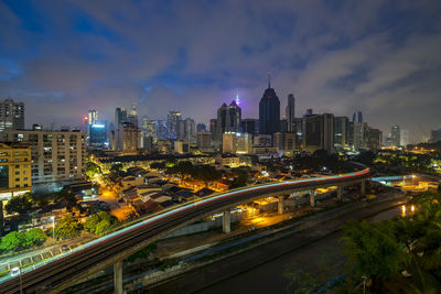 Illuminated buildings in city against sky