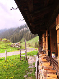 Built structure on field by trees against sky