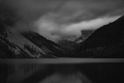 Scenic view of lake by mountains against sky