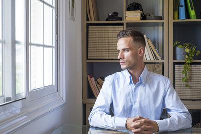 Portrait of doctor standing by window