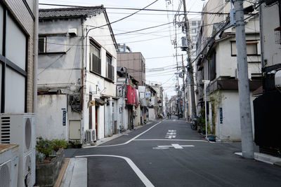 Empty road with buildings in background