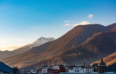 Buildings against mountain during sunset