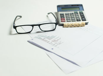 Close-up of eyeglasses on paper against white background