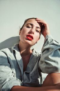 Portrait of young woman with eyes closed against wall