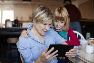 Grandmother and granddaughter looking at tablet computer