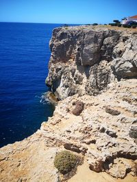 Rock formations on shore against clear sky