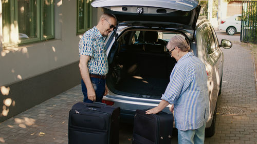 Rear view of man standing in car