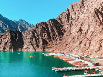 Scenic view of sea and mountains against blue sky