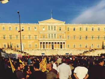 Crowd protesting at greek parliament building against sky