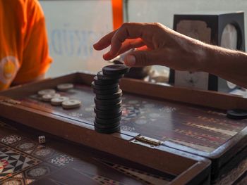 Cropped hand stacking gambling chips on board