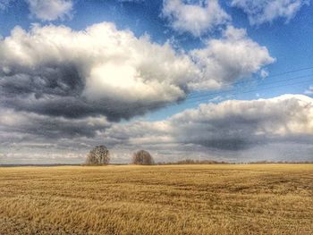 Scenic view of field against cloudy sky
