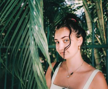 Portrait of young woman with palm tree