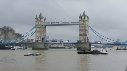 Low angle view of tower bridge above river against sky