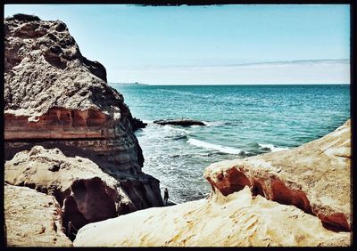 Rock formations by sea against sky