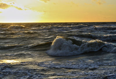 Scenic view of sea wave against sky during sunset