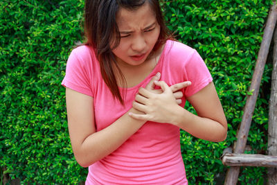 Midsection of woman with chest pain standing outdoors