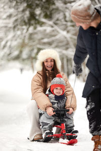 Side view of mother and daughter on snow