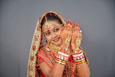 Close-up of smiling young bride against curtain