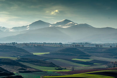 Scenic view of field and mountains against sky