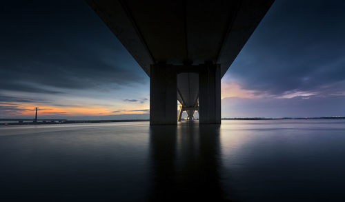 Bridge over sea against sky during sunset