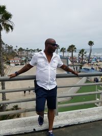 Full length of young man standing on retaining wall