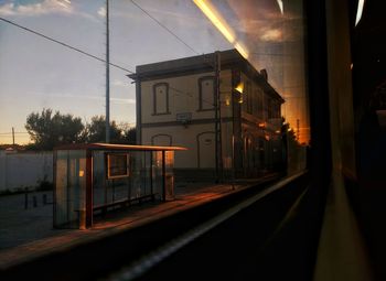 Illuminated railroad station against sky at night