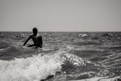 Man in sea against clear sky