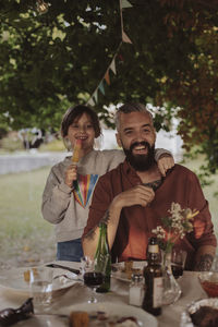 Man and woman holding drink on table