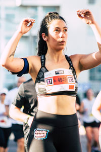 Young woman with arms raised standing in background