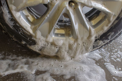 Cropped image of soap sud in car tire