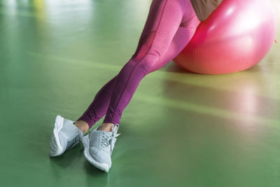 Low section of woman wearing pink shoes