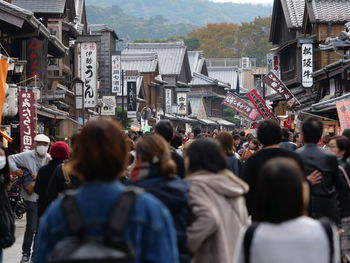 People on street amidst buildings in city