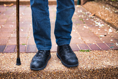 Low section of man standing on footpath