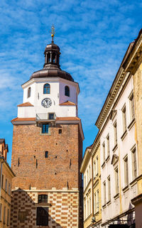 Low angle view of clock tower amidst buildings against sky