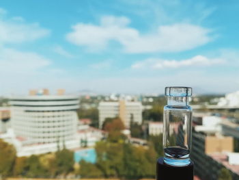 Close-up of glass of building against sky