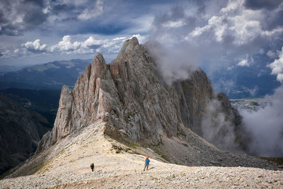 People walking on land against mountain