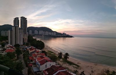 View of city buildings against cloudy sky