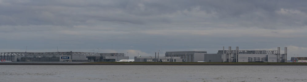 Buildings by sea against sky in city
