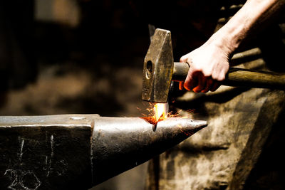 Cropped hand of man working in workshop - blacksmith  