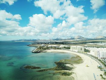 Scenic view of beach against cloudy sky