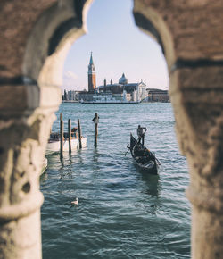 Boats in canal amidst buildings in city