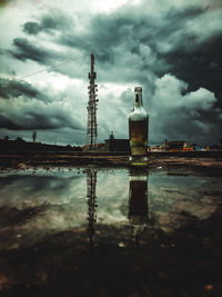 Reflection of factory on water against sky