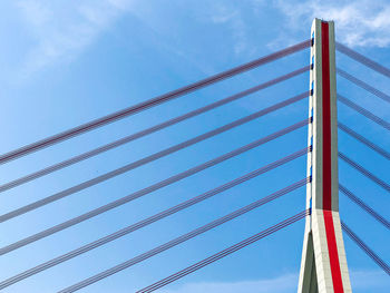 Low angle view of suspension bridge against sky