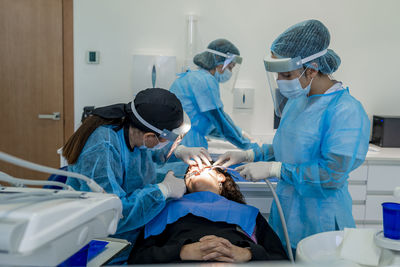 Surgeon with nurses doing surgery of patient in operating room at hospital