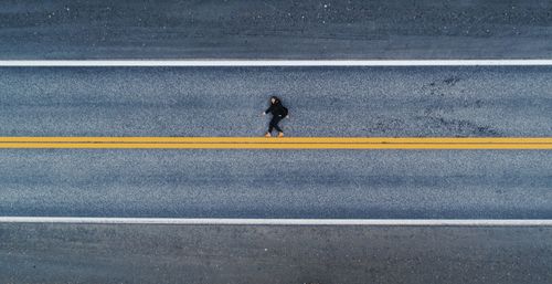Drone shot of man lying on a highway