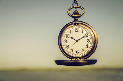 Close-up of clock against sky