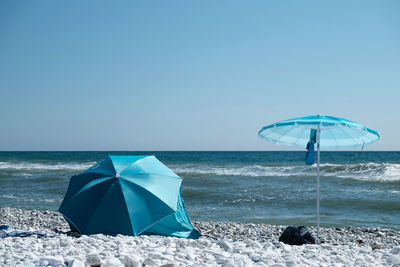 Deck chairs on beach against clear sky