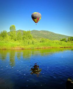 Hot air balloons flying over lake