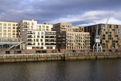 Buildings in city against cloudy sky