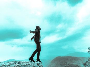 Side view of man standing on land against sky